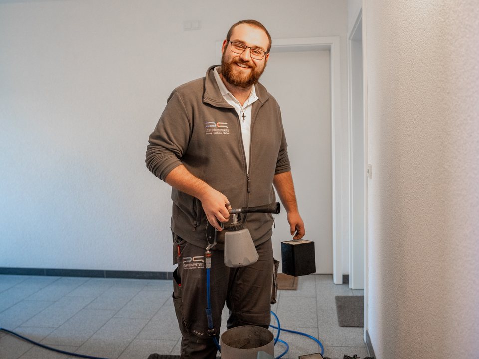 Techniker mit Reinigungsgerät in einer Wohnung