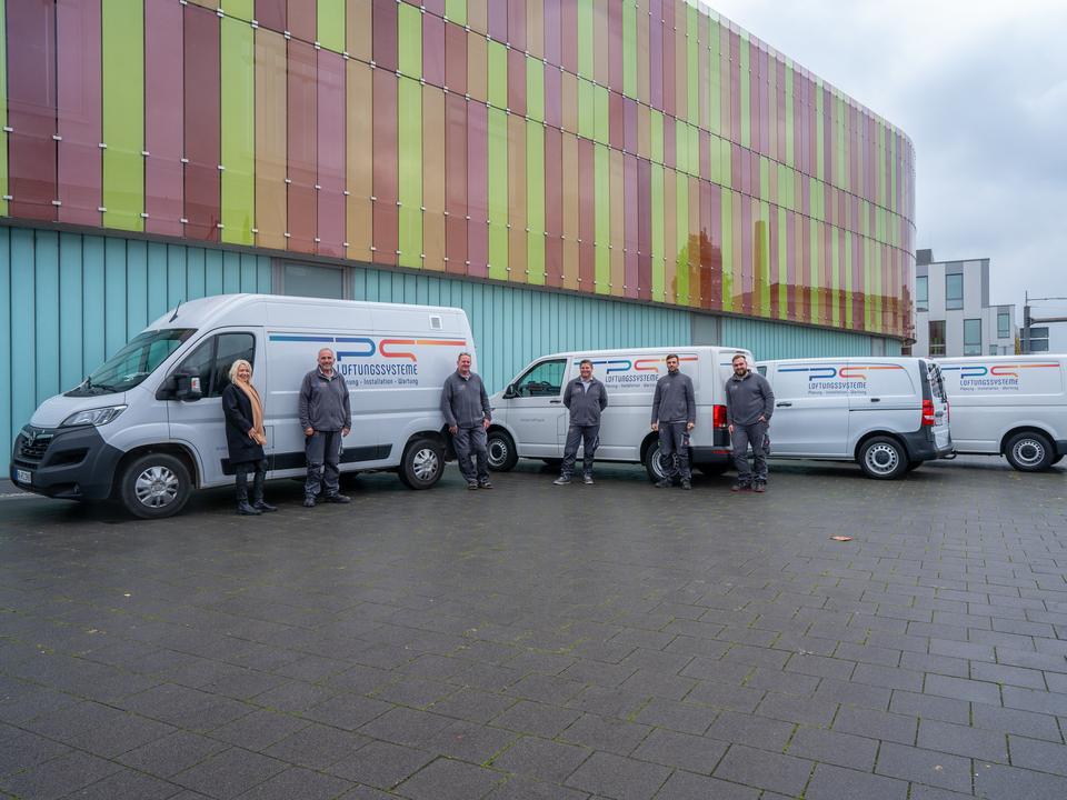 Das Team der PS Lüftungssysteme GmbH vor den Firmenfahrzeugen