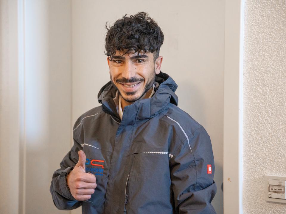 Mitarbeiter in Arbeitsjacke im Treppenhaus