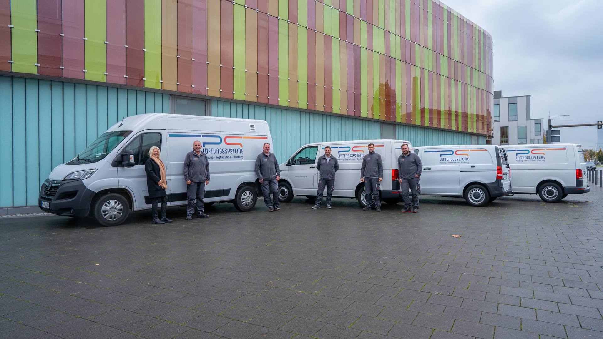 Das Team der PS Lüftungssysteme GmbH vor den Firmenfahrzeugen